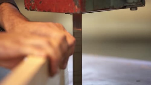 Man Uses Band Saw to Cut Wood Block