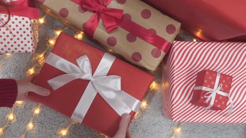 Woman Placing Gift Underneath Christmas Tree