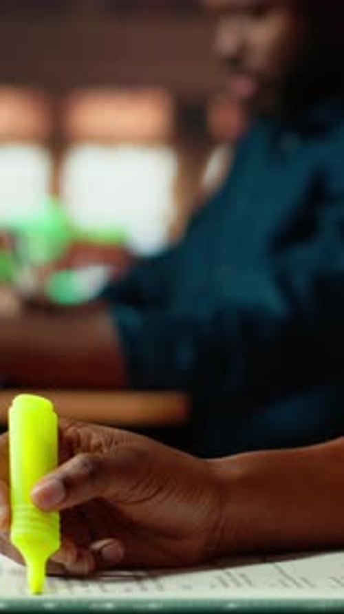 Vertical Video African American Scholar Highlighting the Relevant Information From Class Notes