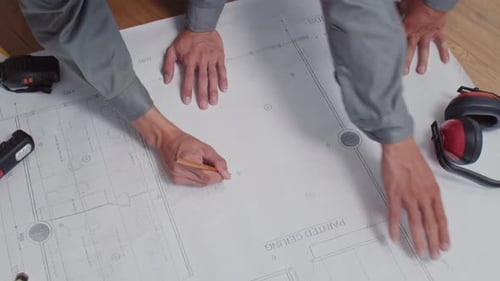 Engineers Looking at Blueprint with Scheme of House and Discussing Renovation