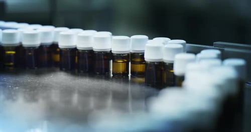 Gros plan de la production de médicaments dans des flacons de verrerie sur des lignes automatiques dans une usine pharmaceutique