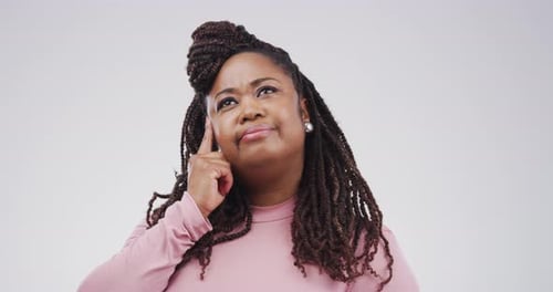 4k video footage of a young woman looking thoughtful against a grey background