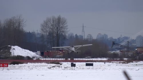 Petit avion Cessna décollant d'un aérodrome local enneigé.