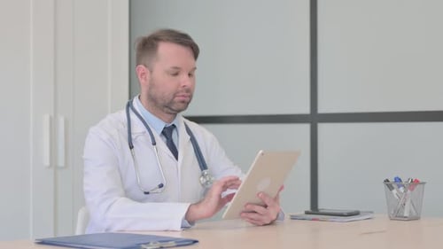 Doctor Using Tablet in Bright Office