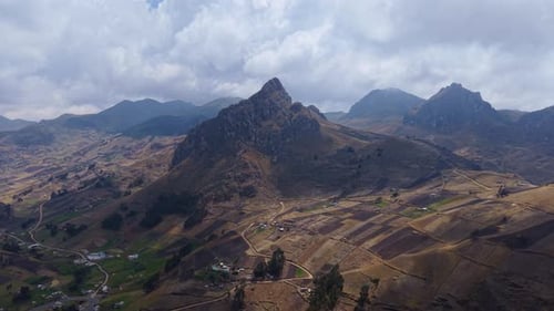 Aerial View of Mountain Terrain Verdant Cultivated Slopes Beneath Clouded Skies Rural Agricultural