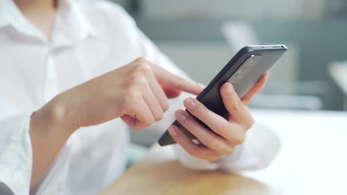 Geschäftsfrau in Nahaufnahme, die im Heimbüro eine Nachricht auf dem Handy tippt, junges Mädchen im Chat