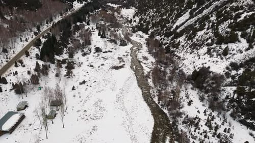 Aerial view of snow capped mountains and fir trees in the winter park