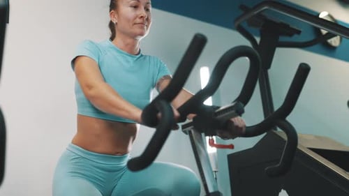 Woman working out on exercise bike in gym