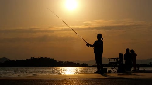 Woman Catching Fish on Sunset Beach
