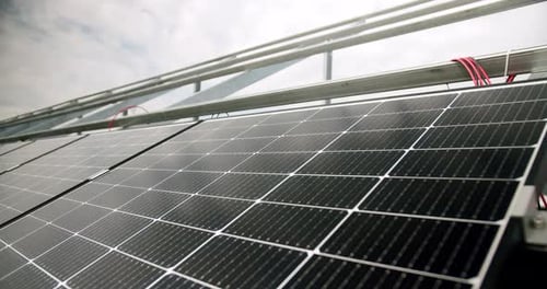 Modern Photovoltaic Panels Illuminated with Sunlight in Daytime on Solar Farm