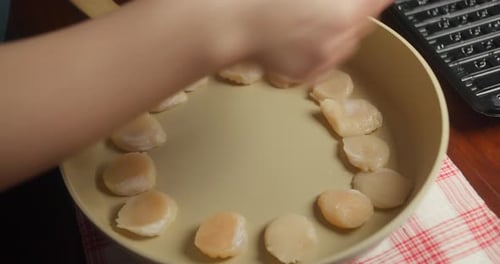 Gros plan de pétoncles retournés pour obtenir un processus de cuisson des fruits de mer faits maison