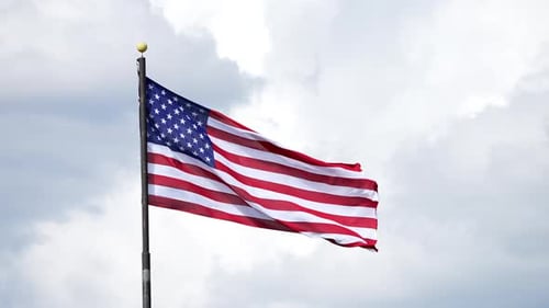 American Flag Waving Against Cloudy Sky