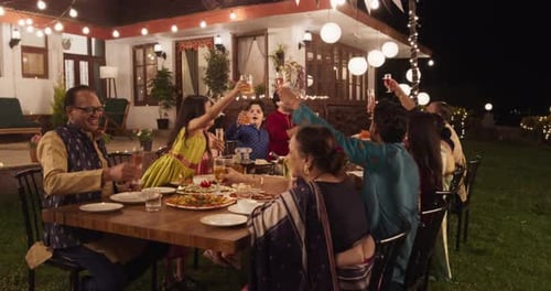 Group Toasting at Dinner Party in an Indian Garden