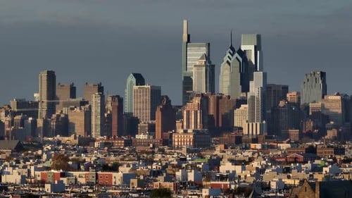 Downtown Philadelphia skyline with housing in foreground. Unique view, long aerial zoom at golden ho
