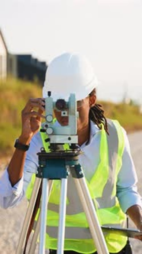 Surveyor uses theodolite on a construction site