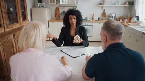 Middleaged Black Woman Real Estate Agent and Spouses Discussing Mortgage Clients and Professional