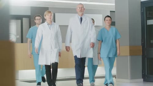 Team of Doctors, Nurses and Assistants Walking through the Lobby of the Hospital. Professional Medi