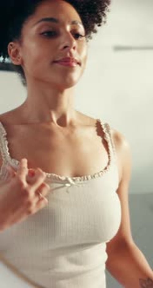 Woman Sprays Deodorant in the Mirror at Home