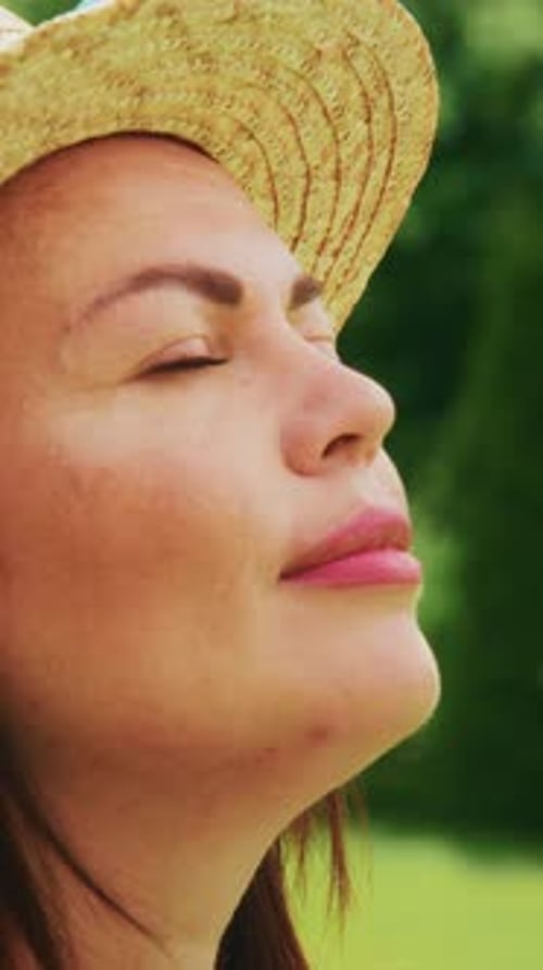 Woman With Hat Enjoying Sunlight Outdoors
