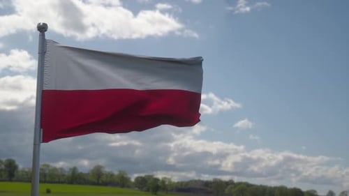 Poland National Flag Waving in Wind Against Blue Sky