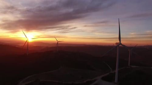 Windmills generating green energy by sunset