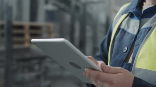 Man In Workwear Using Digital Tablet
