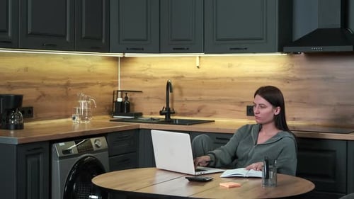 Brunette Woman Works At Home in Kitchen