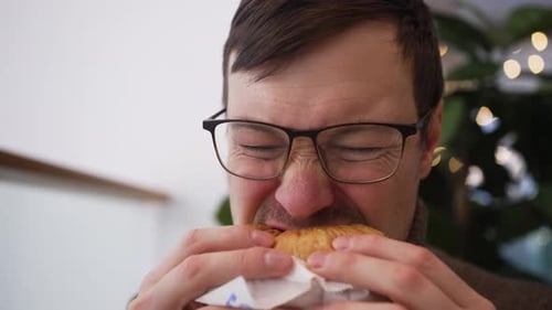 Hungry Man Enjoying Delicious Burger in Cozy Cafe