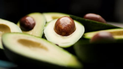 Fresh Avocado Halves Rotating on Plate