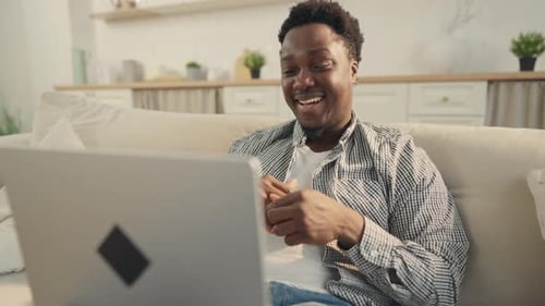 Man Using Laptop For Video Call on Sofa