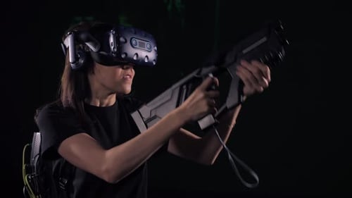 Una chica gamer dispara desde una ametralladora en un estudio de juegos de realidad virtual