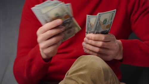 Man counting United States hundred dollar bills