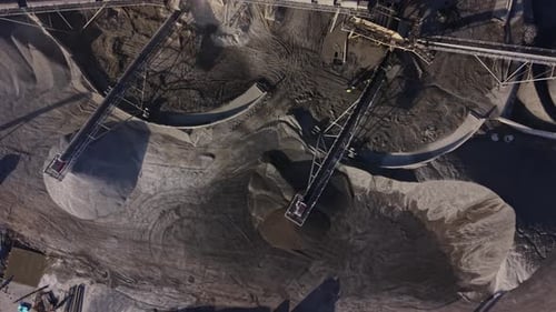 Operations at a quarry site showing machinery and mined materials