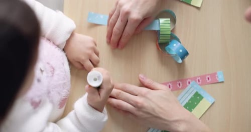 Child with Mother Preparing for Christmas Cutting Out Paper Garlands