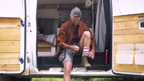 Man Tying Boot in Converted Camper Van