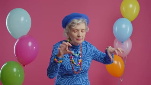 Senior Woman Dancing in Front of Colorful Balloons
