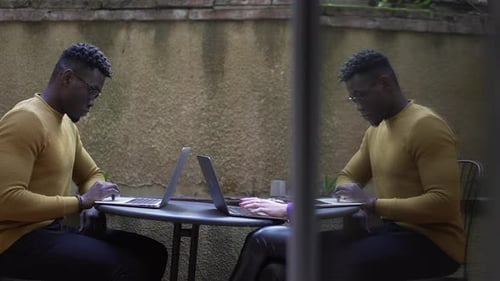 Homem negro africano usando laptop lá fora, trabalhando ao ar livre