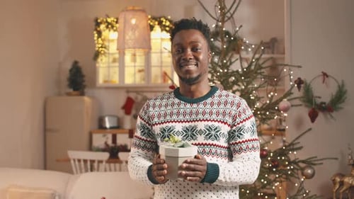 Man Holding Christmas Gift Indoors
