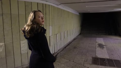 Girl walking out from the underground passage in the night
