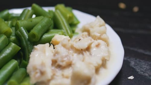 Boiled Green Beans and Steamed Fish on a Plate Black Wooden Table