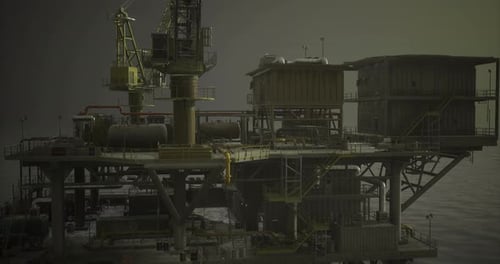Oil Rig at Dusk Surrounded By Calm Waters and Overcast Skies