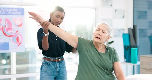 Physical Therapist Assists Senior Woman with Arm Exercise