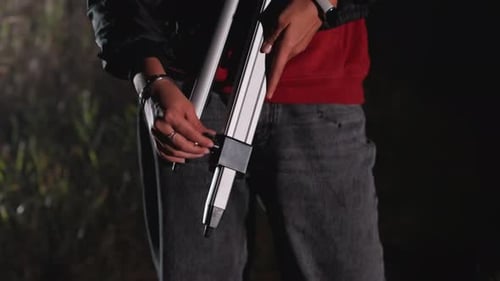 Adjusting a Tripod Outdoors at Night Close Up