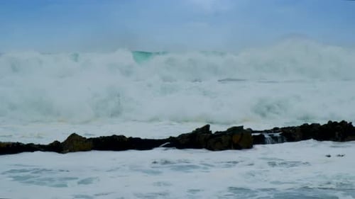 Heavy waves rolling onto rocky shoreline