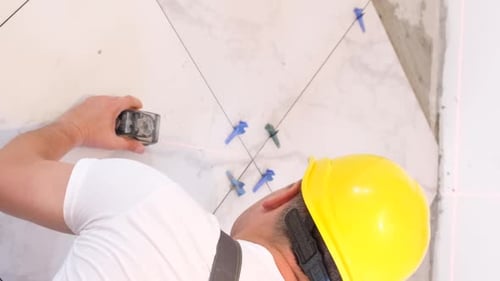 Worker Measures Marble Floor Tiles with Laser Device
