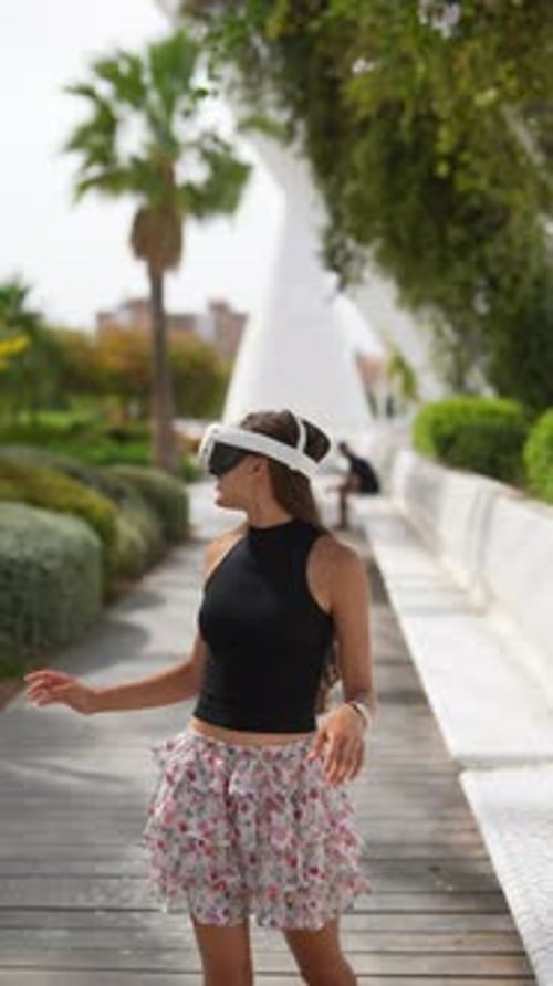 A Woman is Immersed in Using Virtual Reality Technology Outdoors Enjoying the Park Setting