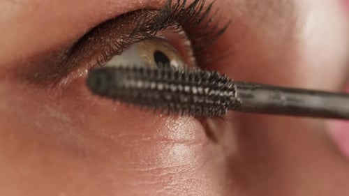Woman Applying Mascara on Eyelashes Close Up