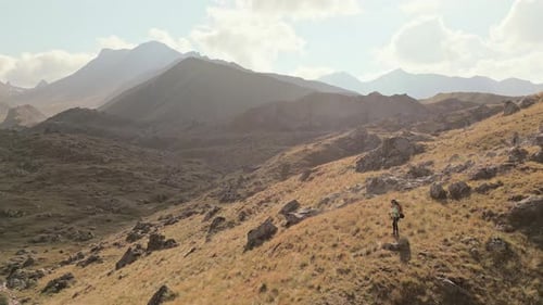 Woman Hiking on Mountain with Backpack and Poles