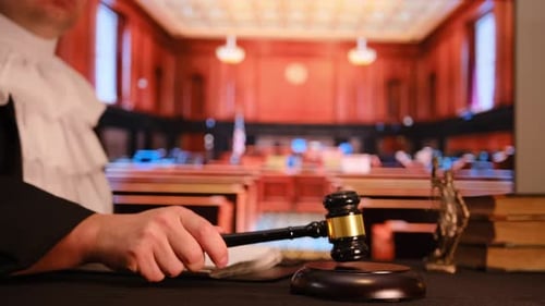 A Judge Firmly Holds a Gavel in a Courtroom Symbolizing the Principles of Justice and the Legal