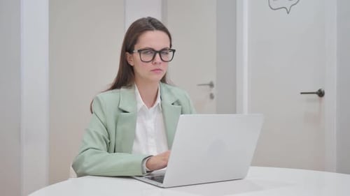 Junge Frau schaut im Büro in die Kamera